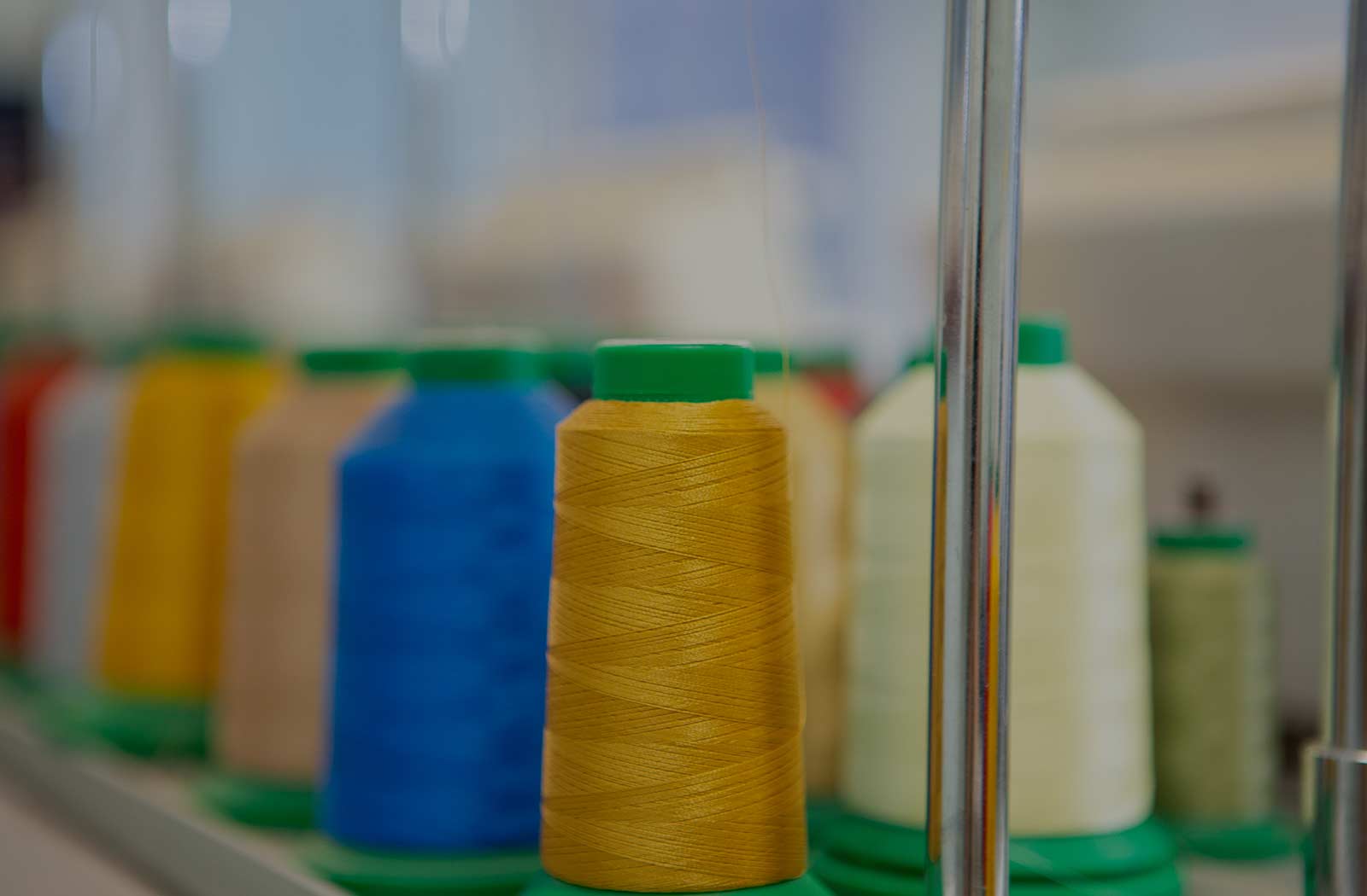 bobbins of thread colored white, yellow, blue