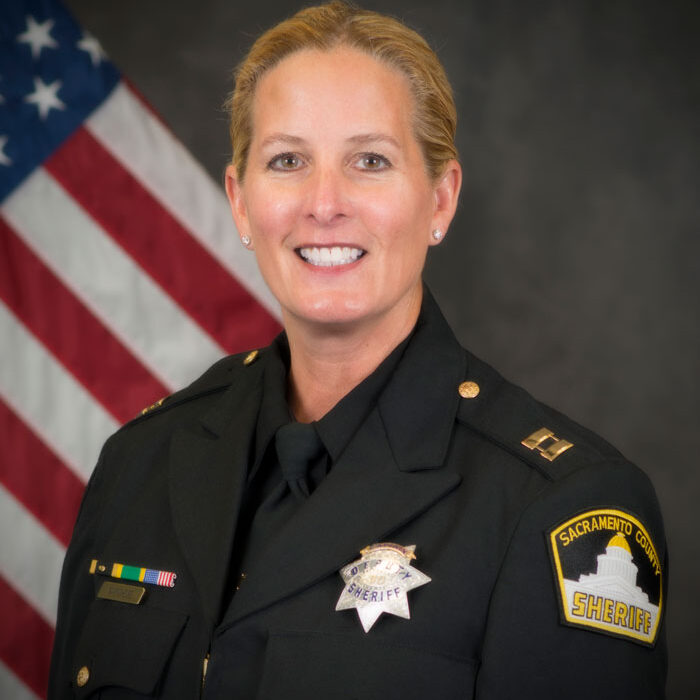 color portrait photograph of Cheif Deputy LeeAnneDra Marchese in her Sheriff's uniform with the US flag in the background